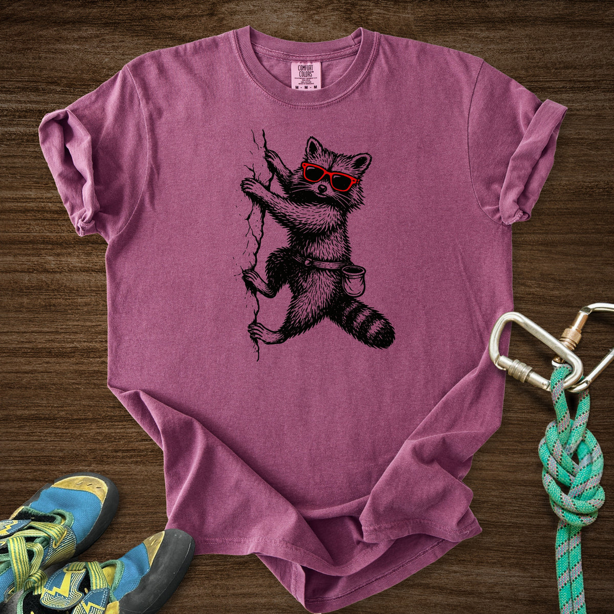 Raccoon Chillin Up a Cliff Premium in Berry — flat lay mockup