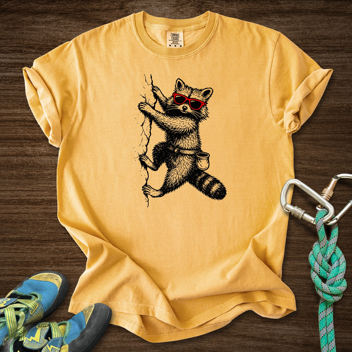 Raccoon Chillin Up a Cliff Premium in Mustard — flat lay mockup